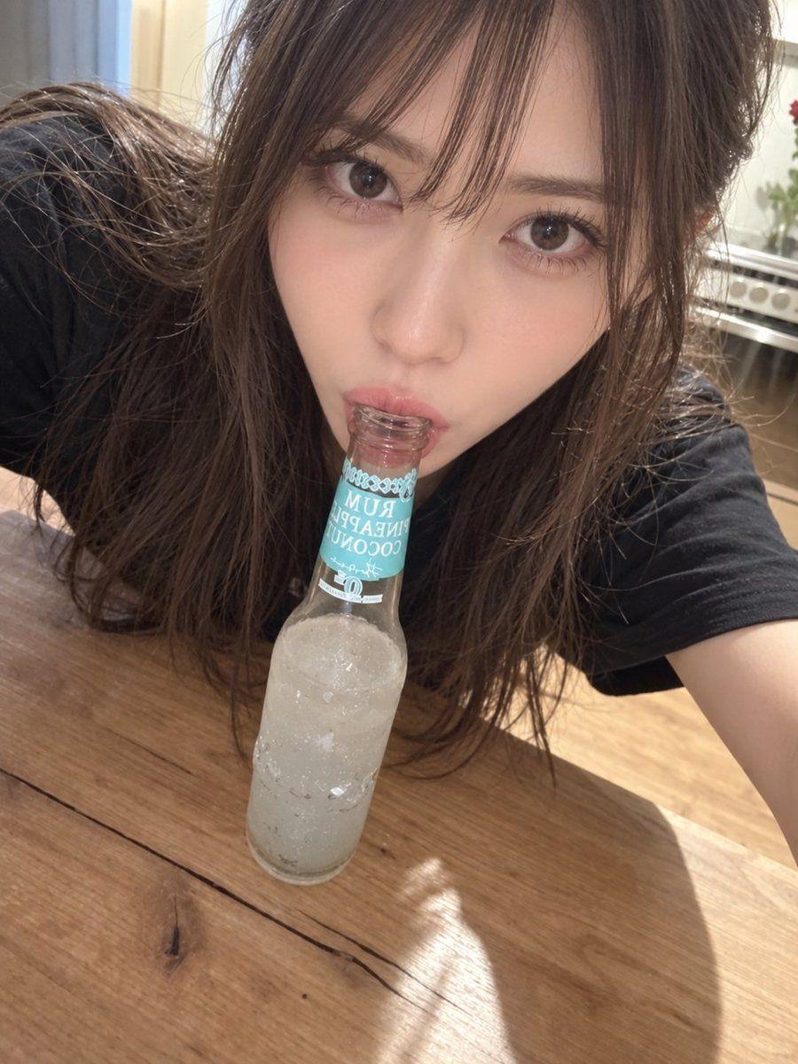 プロンプトのプレビュー: 主題: 瓶口の夜セルフィー 主体: 画面中央、木のテーブルへ身を伏せ、透明な飲料瓶の口を唇に当てる女性の近接セルフィーが主役。 人物・表情: 小さな卵形の顔、濃茶の大きな瞳、細い眉、整った鼻、艶のある…