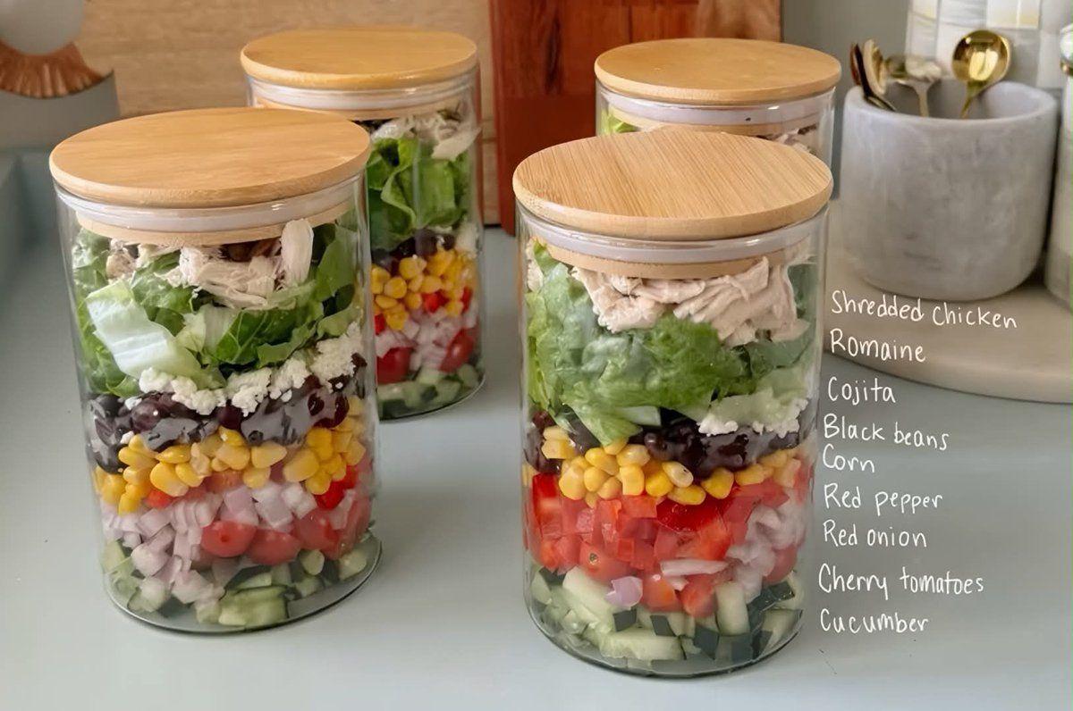 Prompt preview: Create a photorealistic lifestyle food photography scene featuring four clear glass meal-prep jars a…