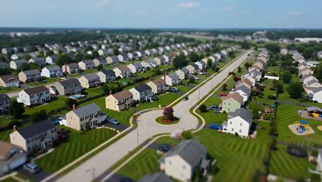プロンプトのプレビュー: 郊外の住宅街を捉えたドローン視点のビデオ