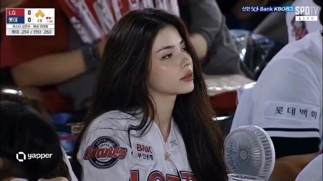 Prévia do prompt: Cena espontânea de espectadora em estádio de beisebol coreano